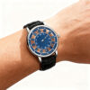 Skeleton jumping hour watch on wrist, featuring blue gradient dial and leather strap, custom manufactured by WatchesHome.